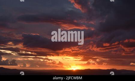 Sonnenuntergang von einem glühenden Rot mit Wolken, ein Sommertag in der toskanischen Landschaft Stockfoto