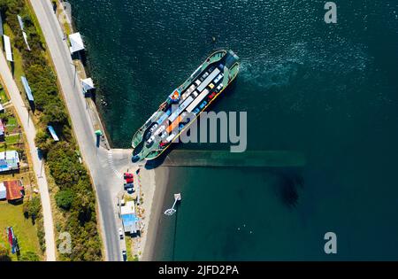 Fahrzeuge, die in Chacao, Chiloe Island, eine Fähre besteigen, um den Kanal in Richtung Pargua auf dem Festland zu überqueren Stockfoto