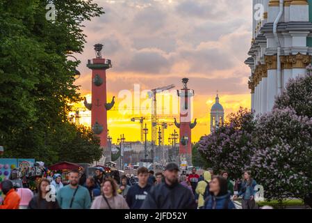 Sankt Petersburg, Russland - 19. Juni 2022: Eine Menschenmenge spaziert mit den Rostral-Säulen und Sonnenuntergang im Hintergrund. Dies ist 10 Uhr der Zeitraum der Zeit Stockfoto