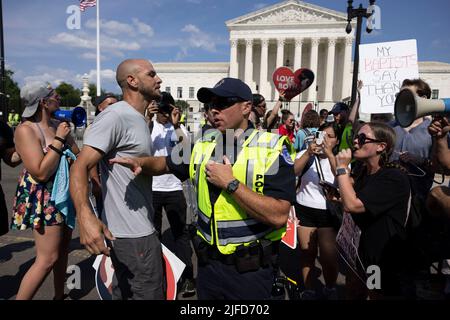 Washington, Usa. 26.. Juni 2022. Ein Mitglied der Capitol Police hält einen Anti-Abtreibungsaktivisten zurück, der während eines zweitägigen Protestes vor dem Obersten Gerichtshof mit Abtreibungsrechtlern argumentierte. Mehr als 100 Demonstranten versammelten sich vor dem Obersten Gerichtshof der Vereinigten Staaten zu einer Kundgebung über Abtreibungsrechte. Die Kundgebung findet eine Woche nach einer Stellungnahme des Obersten Gerichtshofs der Vereinigten Staaten in Dobbs v. Jackson Women's Health Organization statt, in der Roe v. Wade und das Recht auf Abtreibung abgelehnt wurden. Kredit: SOPA Images Limited/Alamy Live Nachrichten Stockfoto