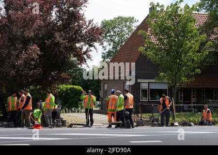 Eine Gruppe osteuropäischer Arbeiter wartet auf Anweisungen bezüglich Straßenarbeiten von der niederländischen Telefongesellschaft KPN Stockfoto