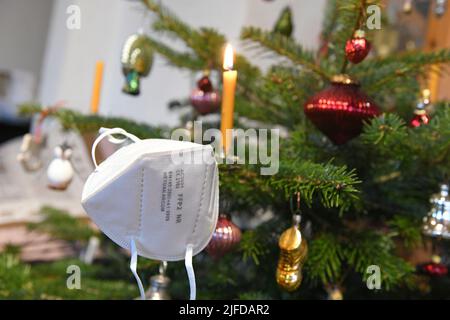 FFP2-Maske hängt auf einem Weihnachtsbaum, Österreich, Europa - FFP2 Maske hängt an einem Weihnachtsbaum, Österreich, Europa Stockfoto