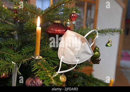 FFP2-Maske hängt auf einem Weihnachtsbaum, Österreich, Europa - FFP2 Maske hängt an einem Weihnachtsbaum, Österreich, Europa Stockfoto