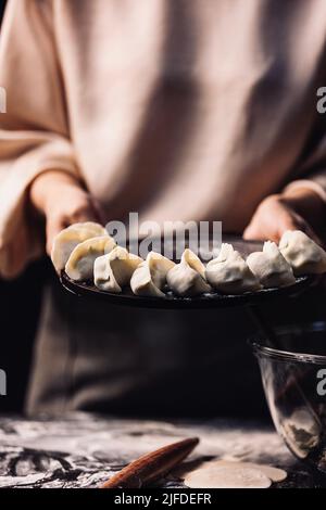 Zeigt einen Teller mit gewickelten Knödeln, den Prozess der Herstellung von traditionellen chinesischen Lebensmittelknödeln - Stock Foto Stockfoto