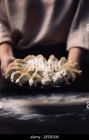 Zeigt einen Teller mit gewickelten Knödeln, den Prozess der Herstellung von traditionellen chinesischen Lebensmittelknödeln - Stock Foto Stockfoto