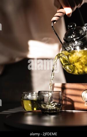 Teekünstler gießt reinen Jasmintee, ein traditionelles chinesisches Getränk - Stock photo Stockfoto
