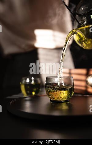 Teekünstler gießt reinen Jasmintee, ein traditionelles chinesisches Getränk - Stock photo Stockfoto