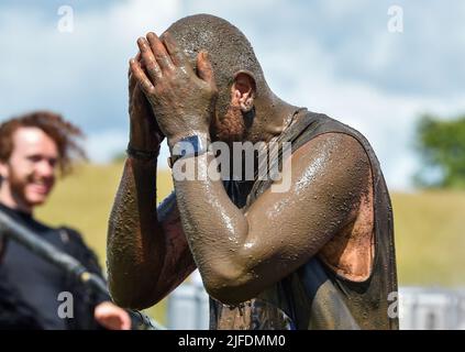 Brighton UK 2. July 2022 - Hunderte von Teilnehmern werden in Schlamm gehüllt, wenn sie an der Veranstaltung Race for Life Pretty Muddy im Stanmer Park in Brighton in Aid of Cancer Research UK teilnehmen. : Credit Simon Dack / Alamy Live News Stockfoto