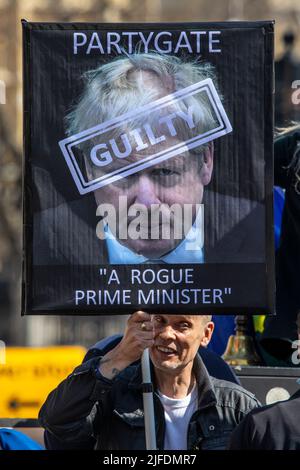 London, Großbritannien - 20. 2022. April: Ein Protestant vor dem Parlamentsgebäude in Westminster, London, protestiert gegen Boris Johnson und die Partygate Stockfoto