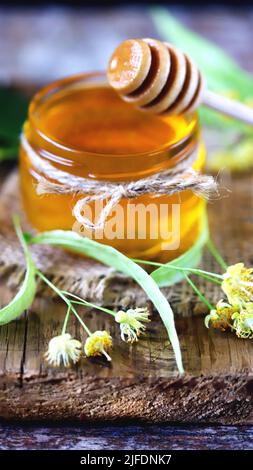 Linden Honig in einem Glas. Blätter und Blüten von Linden. Frischer Lindenhonig. Stockfoto