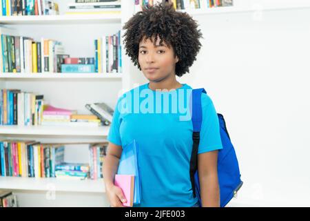 Ernsthafte afroamerikanische Studentin mit blauem Hemd im Klassenzimmer der Universität Stockfoto