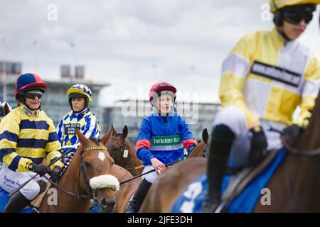 Eine Gruppe weiblicher Amateur-Jockeys, darunter ab O'Connor, Stephanie Jardeback, Jessica Bedi, stehen vor den Starttoren der York Races Stockfoto