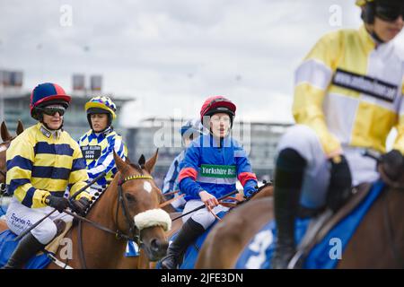 Eine Gruppe weiblicher Amateur-Jockeys, darunter ab O'Connor, Stephanie Jardeback, Jessica Bedi, stehen vor den Starttoren der York Races Stockfoto