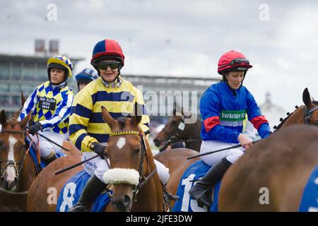 Eine Gruppe weiblicher Amateur-Jockeys, darunter ab O'Connor, Stephanie Jardeback, Jessica Bedi, stehen vor den Starttoren der York Races Stockfoto