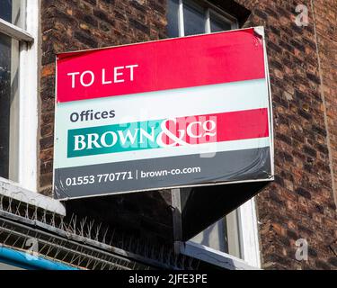 Norfolk, Großbritannien - 8. 2022. April: Ein SCHILD ÜBER einem leeren Bürogebäude in der Stadt Kings Lynn in Norfolk, Großbritannien, ZU VERMIETEN. Stockfoto