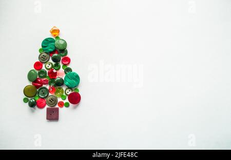 Apfelbaum oder Weihnachtsbaum aus Knöpfen grün, rot. Weißer Hintergrund, Kopierbereich. Stockfoto