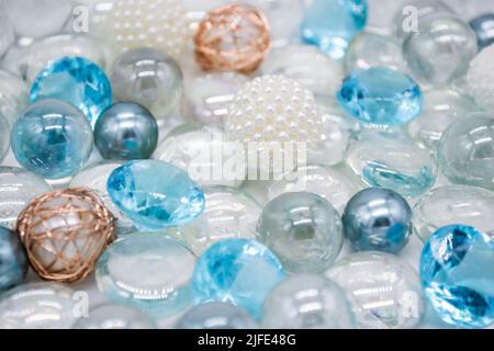 Schöner Hintergrund aus transparenten, hellblauen Glasperlen, Kristallen und weißen Perlen. Speicherplatz kopieren. Stockfoto