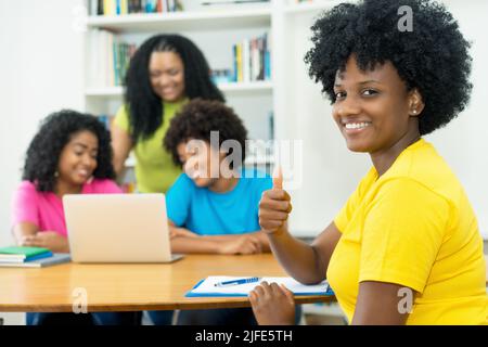 Gruppe lachender afroamerikanischer Informatikstudenten, die an der Universität Softwareentwicklung und Programmierung lernen Stockfoto