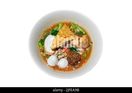 Yentafo Eiernudeln Suppe mit rosa Sauce und Fischbällchen, Garnelenkugel, gehacktes Schweinefleisch, gebratenes Wonton, gebratenen Taro und Morgenruhm in weißer Schüssel isoliert o Stockfoto