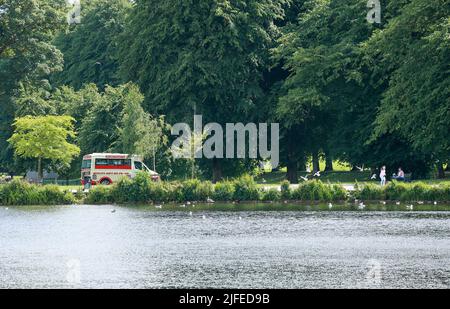 Lurgan Park, Lurgan, County Armagh, Nordirland, Großbritannien. 02. Juli 2022. Wetter in Großbritannien – warm und sonnig, wenn Lücken in einem grau bewölkten Himmel erscheinen. Ein angenehmer Nachmittag mit einem Eiswagen für diejenigen am Parksee. Kredit: CAZIMB/Alamy Live Nachrichten. Stockfoto