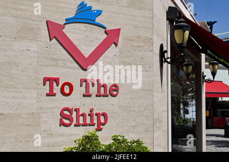 Kusadasi, Türkei - Juni 2022. Mai: Schild an der Wand des Kreuzfahrtterminals zeigt Passagieren den Weg zu ihrem Schiff. Stockfoto