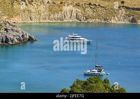 Lindos, Rhodos, Griechenland - 2022. Mai: Luftaufnahme von Luxusbooten, die in der Bucht vor dem Stadtstrand festgemacht sind Stockfoto
