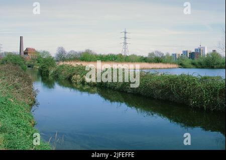 Der Coppermill Stream im Frühjahr auf Walthamstow Wetlands, North London, Großbritannien, mit Blick auf das Gebäude des Motorhauses Stockfoto