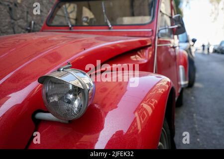 Eine Nahaufnahme eines roten Retro-Autos, das in der Ecke geparkt ist Stockfoto