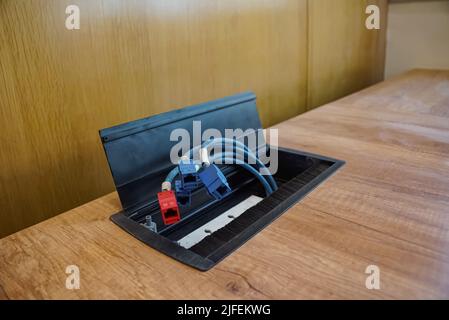 Weibliche LAN-Anschlüsse auf dem Holztisch. LAN-Kabel auf dem Tisch. Stockfoto