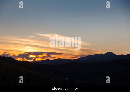 Rosa und lila Sonnenuntergang in den Bergen. Sonnenuntergang über den Bergen Silhouette, rot, rosa, blaue Farben der Abenddämmerung, Karpaten, Stockfoto