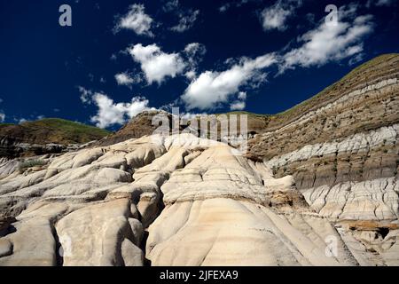 Frau, die auf einem Sandstein steht und die Hoodoos und Felsformationen in den kanadischen Badlands, Drumheller, Alberta, Kanada, fotografiert Stockfoto