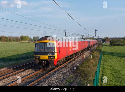 DB Cargo betreibt Royal Mail-Postzüge der Klasse 325, die in Brock an der Hauptlinie der Westküste in Lancashire die Landschaft durchquern Stockfoto