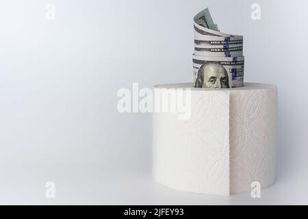 Inflation. Der Wert des Geldes. Amerikanische 100-Dollar-Scheine wurden auf hellweißem, grauem Hintergrund in Toilettenpapier eingelegt. Geschäfts- und Finanzthemen. Stockfoto