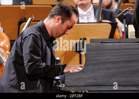 02. Juli 2022, Schleswig-Holstein, Lübeck: Der Pianist Igor Levit tritt beim Eröffnungsvorkonzert des Schleswig-Holstein Musik Festivals SMFH zusammen mit dem NDR Elbphilharmonie Orchestra unter der Leitung von Alan Gilbert auf. Die SHMF wurde 1986 gegründet. Es gilt mit mehr als 200 Konzerten, 126 Spielstätten und einem Ticketkontingent von fast 200.000 Tickets als Deutschlands größtes Klassik-Festival. Foto: Axel Heimken/dpa Stockfoto