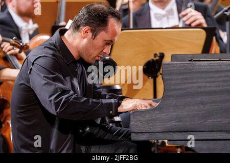 02. Juli 2022, Schleswig-Holstein, Lübeck: Der Pianist Igor Levit tritt beim Eröffnungsvorkonzert des Schleswig-Holstein Musik Festivals SMFH zusammen mit dem NDR Elbphilharmonie Orchestra unter der Leitung von Alan Gilbert auf. Die SHMF wurde 1986 gegründet. Es gilt mit mehr als 200 Konzerten, 126 Spielstätten und einem Ticketkontingent von fast 200.000 Tickets als Deutschlands größtes Klassik-Festival. Foto: Axel Heimken/dpa Stockfoto