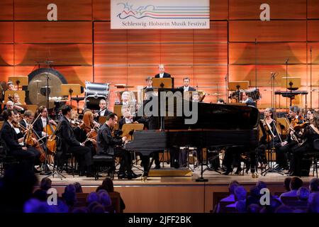 02. Juli 2022, Schleswig-Holstein, Lübeck: Der Pianist Igor Levit tritt beim Eröffnungsvorkonzert des Schleswig-Holstein Musik Festivals SMFH zusammen mit dem NDR Elbphilharmonie Orchestra unter der Leitung von Alan Gilbert auf. Die SHMF wurde 1986 gegründet. Es gilt mit mehr als 200 Konzerten, 126 Spielstätten und einem Ticketkontingent von fast 200.000 Tickets als Deutschlands größtes Klassik-Festival. Foto: Axel Heimken/dpa Stockfoto