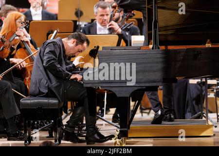 02. Juli 2022, Schleswig-Holstein, Lübeck: Der Pianist Igor Levit tritt beim Eröffnungsvorkonzert des Schleswig-Holstein Musik Festivals SMFH zusammen mit dem NDR Elbphilharmonie Orchestra unter der Leitung von Alan Gilbert auf. Die SHMF wurde 1986 gegründet. Es gilt mit mehr als 200 Konzerten, 126 Spielstätten und einem Ticketkontingent von fast 200.000 Tickets als Deutschlands größtes Klassik-Festival. Foto: Axel Heimken/dpa Stockfoto