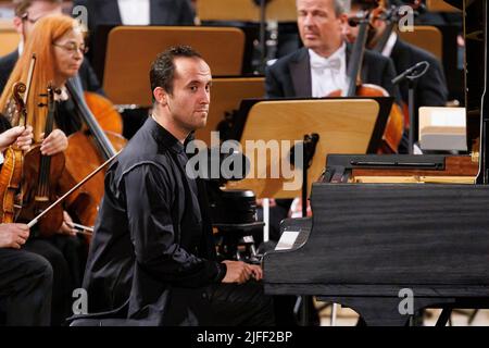 02. Juli 2022, Schleswig-Holstein, Lübeck: Der Pianist Igor Levit tritt beim Eröffnungsvorkonzert des Schleswig-Holstein Musik Festivals SMFH zusammen mit dem NDR Elbphilharmonie Orchestra unter der Leitung von Alan Gilbert auf. Die SHMF wurde 1986 gegründet. Es gilt mit mehr als 200 Konzerten, 126 Spielstätten und einem Ticketkontingent von fast 200.000 Tickets als Deutschlands größtes Klassik-Festival. Foto: Axel Heimken/dpa Stockfoto