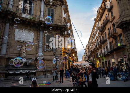 Eine Straßenkünstlerin bläst Seifenblasen, während Touristen spazieren gehen und die Aussicht auf die Stadt bewundern Stockfoto