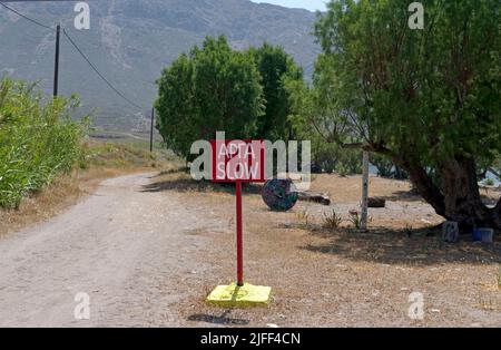 Griechisches Schild für SLOW / ARGA am Strand von Eristos, Tilos Island, Dodekanese, in der Nähe von Rhodos Stockfoto