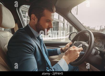 Nahaufnahme eines hübschen kaukasischen Geschäftsmannes in Anzug mit Autoschlüssel Stockfoto