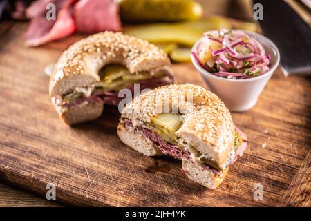 Bagel gefüllt mit saftiger Rinderpastrami zusammen mit Gurken. Stockfoto