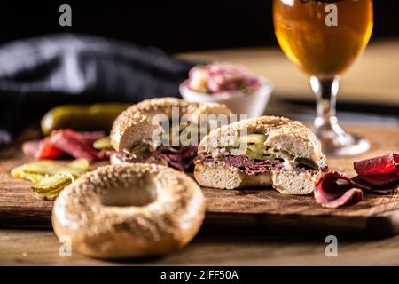 Bagel gefüllt mit saftiger Rinderpastrami zusammen mit Gurken. Stockfoto