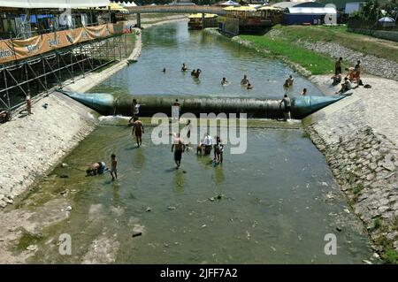 gypsy Community Abkühlung und Fang von kleinen Fischen durch die Hände in den flachen Gewässern des Flusses Bjelica in Guca, Serbien Stockfoto