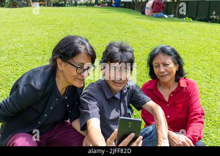Gruppe von lateinamerikanischen Freunden mittleren Alters, die ein Selfie machen und Spaß in einem Park haben Stockfoto