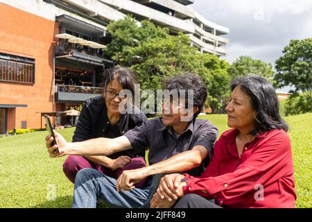 Gruppe von lateinamerikanischen Freunden mittleren Alters, die ein Selfie machen und Spaß in einem Park haben Stockfoto