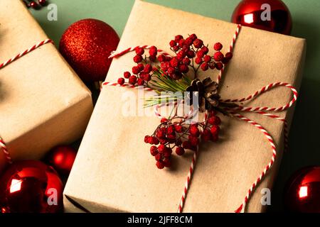 Weihnachtsgeschenkboxen mit roten Weihnachtskugeln. Umweltfreundliches Verpackungskonzept. Blick von oben. Stockfoto