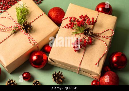 Weihnachtsgeschenkboxen mit roten Weihnachtskugeln. Umweltfreundliches Verpackungskonzept. Blick von oben. Stockfoto