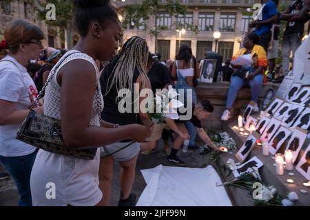 Auf dem Idrissa Diallo Platz werden Demonstranten mit brennenden Kerzen und Blumen zu einem Altar getragen. Hunderte von Menschen demonstrierten im Zentrum von Barcelona und bildeten schließlich einen Altar auf dem Idrissa Diallo Platz anlässlich des Massakers von Melilla, bei dem mehr als dreißig afrikanische Migranten aufgrund der Repression der marokkanischen Polizei starben, nachdem sie versucht hatten, den spanischen Grenzzaun zu überspringen. Stockfoto