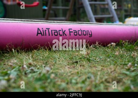 AirTrack Factory Matte auf Gras. Gymnastik aufgeblasene Matte für Sprünge und Trainingstricks. Stockfoto